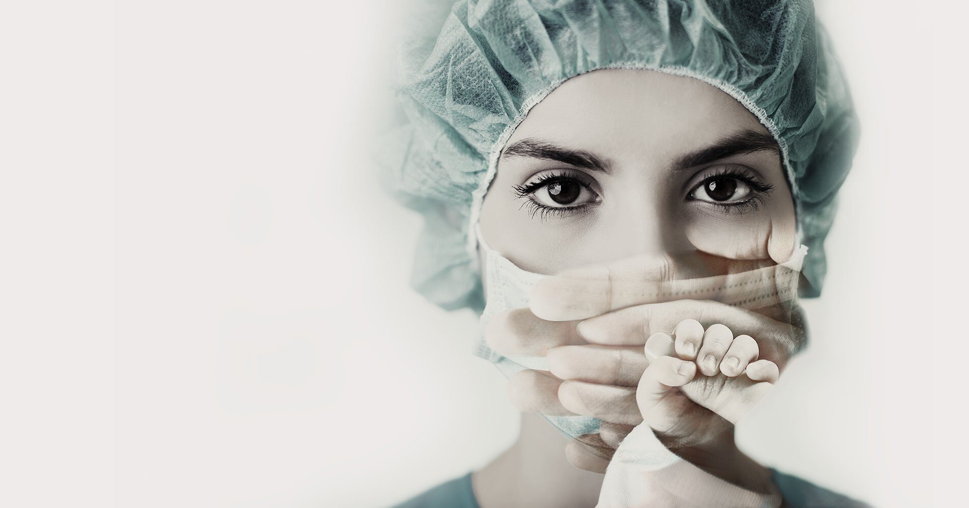 Operatrice sanitaria in sala operatoria che stringe la mano di un neonato